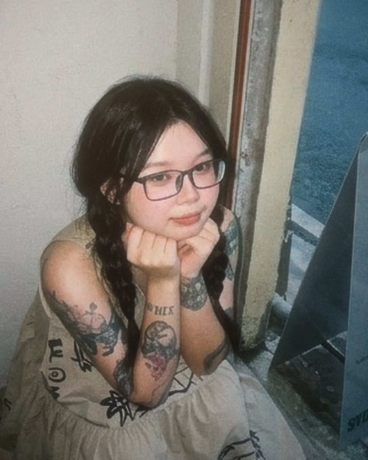 Clare Low in glasses with long braids, chin resting on her hands